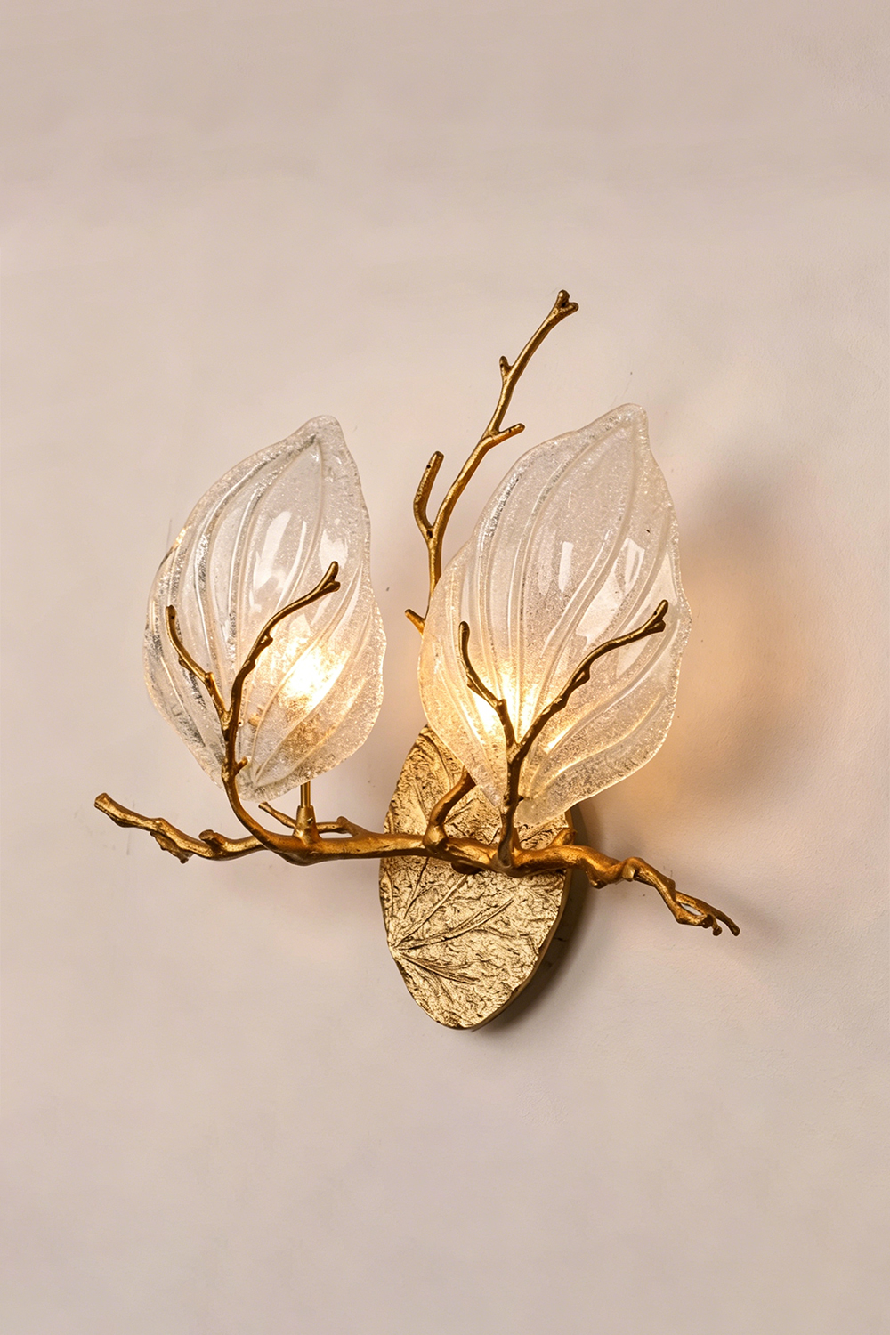Magnolia Arbor Brass Wall Lamp | Brass, Glass | Frontal angled view of the fully lit organic brass lamp against a warm plain backdrop | Isolated shot | Samu Lamp
