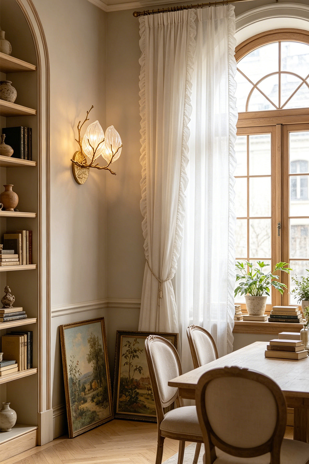 Magnolia Arbor Brass Wall Lamp | Brass, Glass | Mounted on a wall near a classic wooden dining table and bookshelves in a room with a large arched window | Samu Lamp