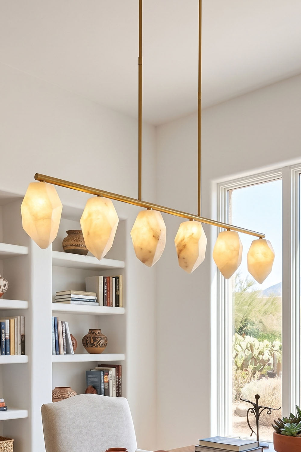 Manon Alabaster Drop Linear Chandelier | Natural Alabaster and Brass | Hanging in a bright study room over a table near white bookshelves | Samu Lamp