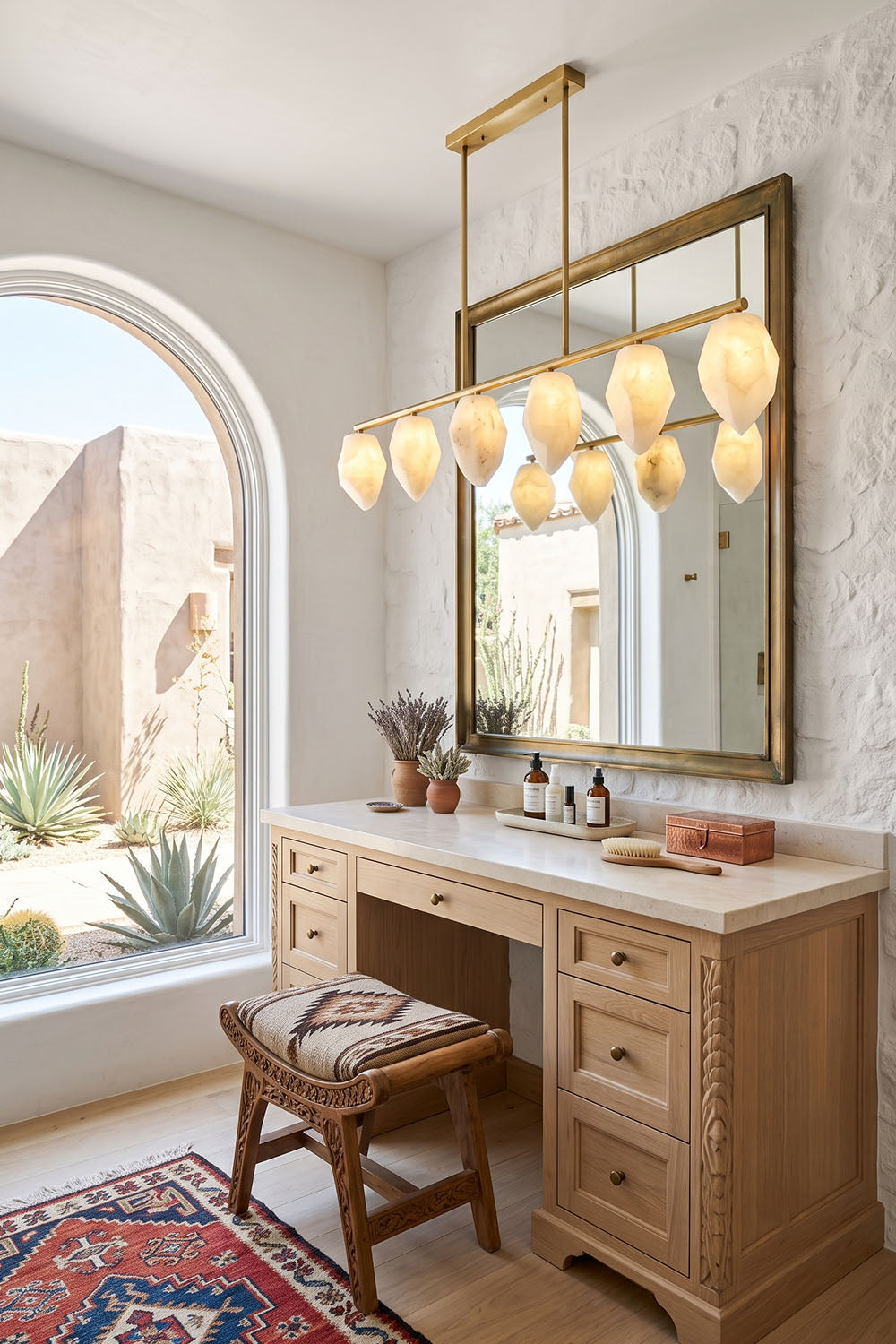 Manon Alabaster Drop Linear Chandelier | Natural Alabaster and Brass | Illuminating a wooden vanity desk in a bathroom with an arched window | Samu Lamp