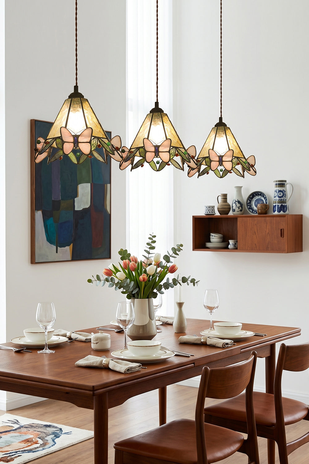 Mariposa Canopy Stained Glass Pendant Lamp | Glass, Metal | A row of three matching stained glass pendants suspended over a long dark wood dining table and chairs | Samu Lamp