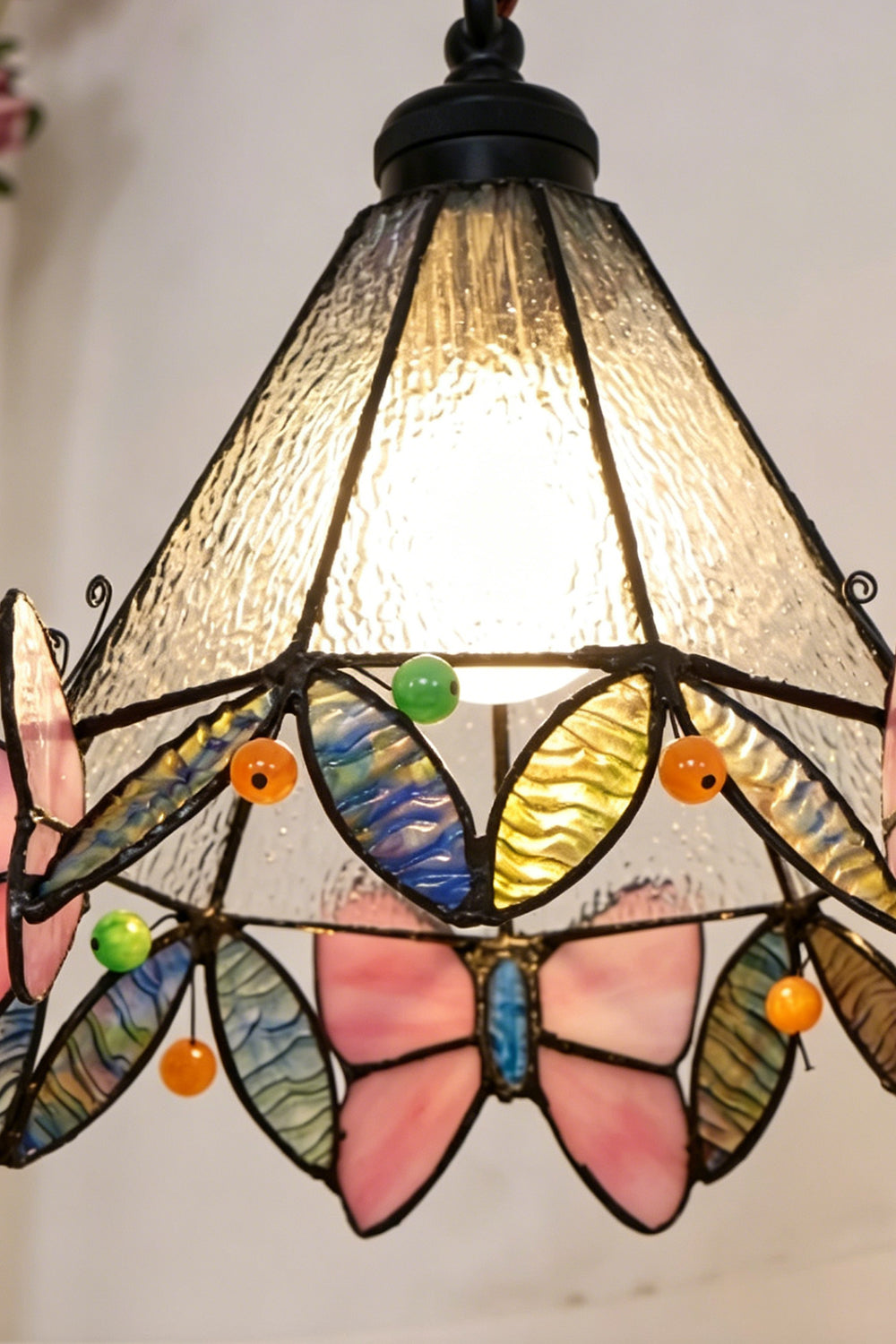 Mariposa Stained Glass Table Lamp | Glass, Metal | Detailed view of the fully illuminated Tiffany shade radiating a warm texture of mosaic art glass | Detail shot | Samu Lamp