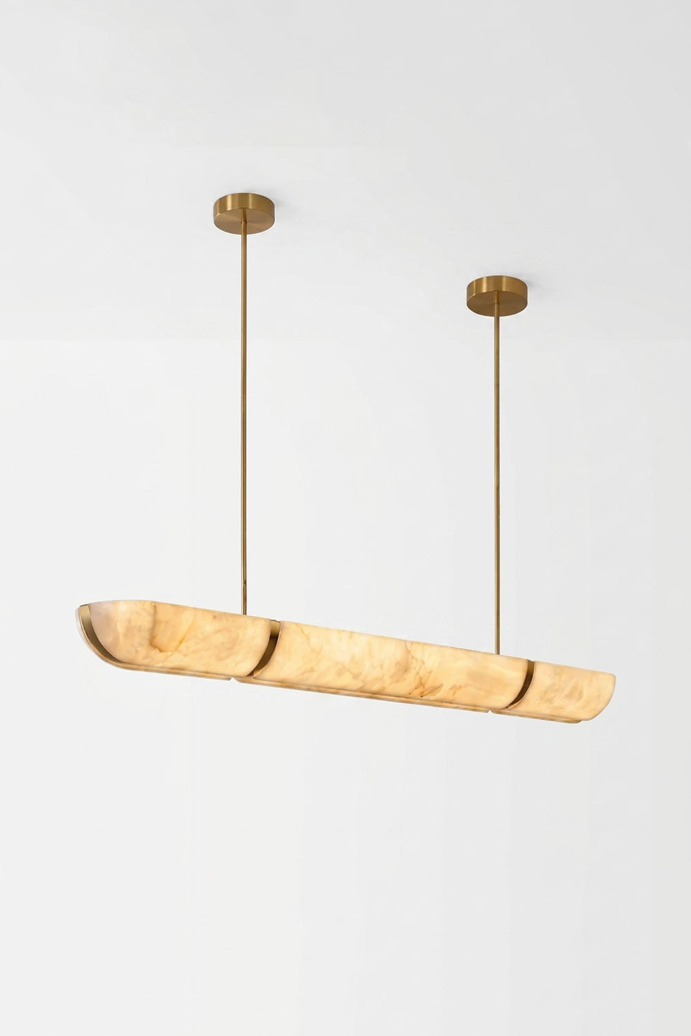 Marlen Alabaster Bar Linear Pendant Light hanging in a modern setting with gold accents.