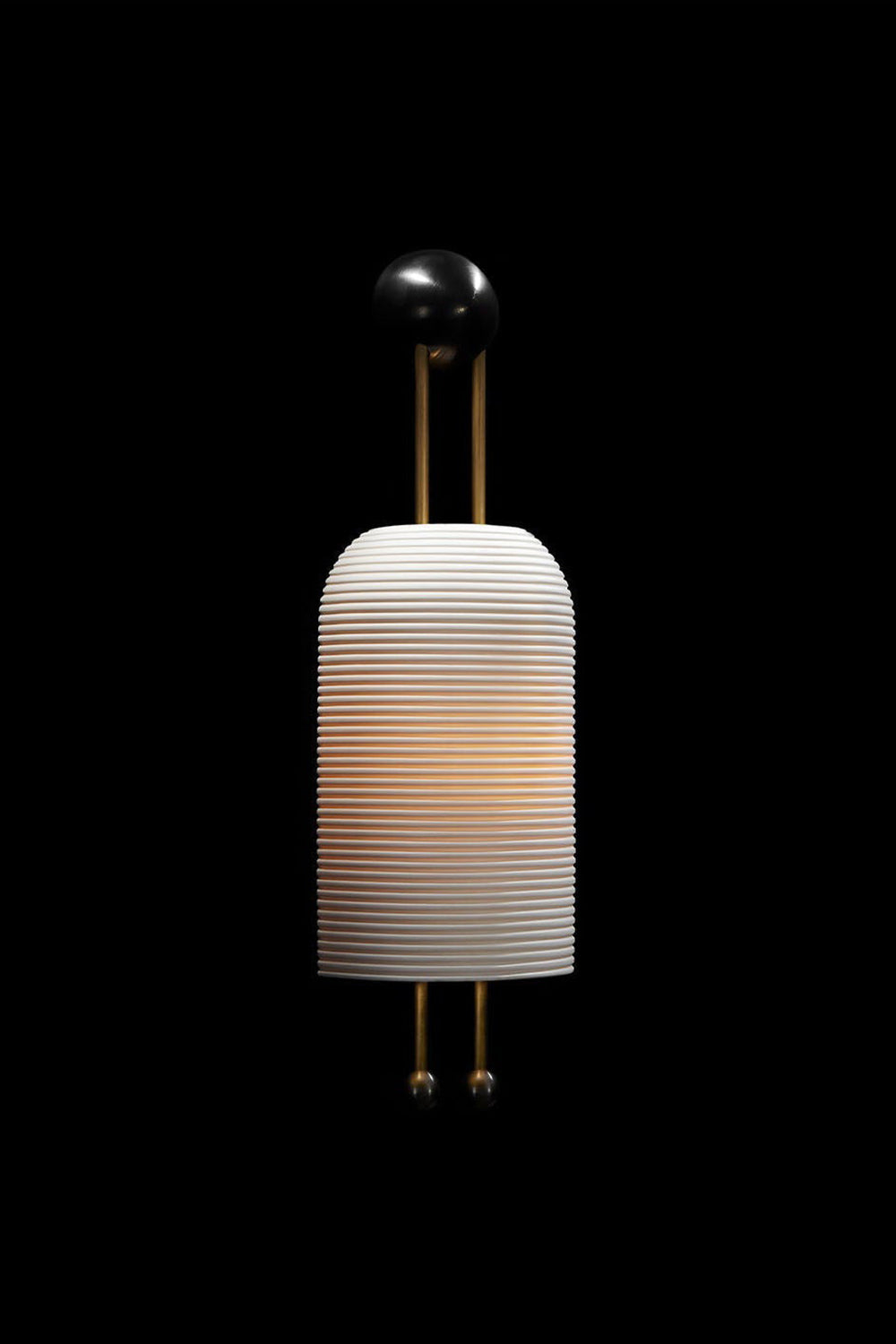 Marlow Linear Ribbed Glass Wall Lamp | Glass, Metal | Dramatic dark studio shot of the fully illuminated ribbed glass sconce glowing intensely against a solid black background | Samu Lamp