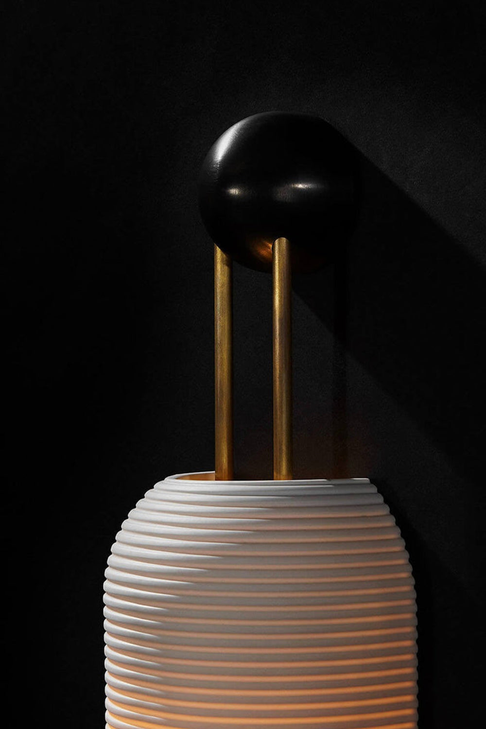 Marlow Linear Ribbed Glass Wall Lamp | Glass, Metal | Macro close-up under dark studio lighting highlighting the top black mounting base and fine horizontal glass ribs | Detail shot | Samu Lamp