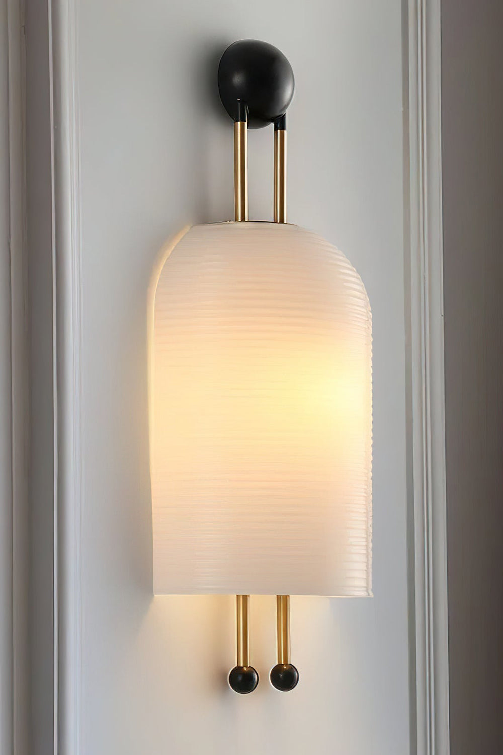 Marlow Linear Ribbed Glass Wall Lamp | Glass, Metal | Close-up focus on the illuminated diffused glass variant showcasing its clean seamless capsule silhouette and gold hardware | Samu Lamp