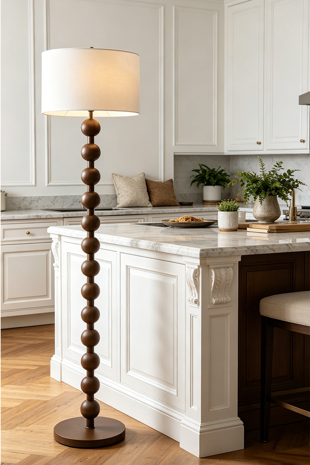 Marlow Stacked Wood Floor Lamp | Wood, Fabric | Standing gracefully in a bright classical kitchen space next to a white island counter with wooden bar stools | Samu Lamp