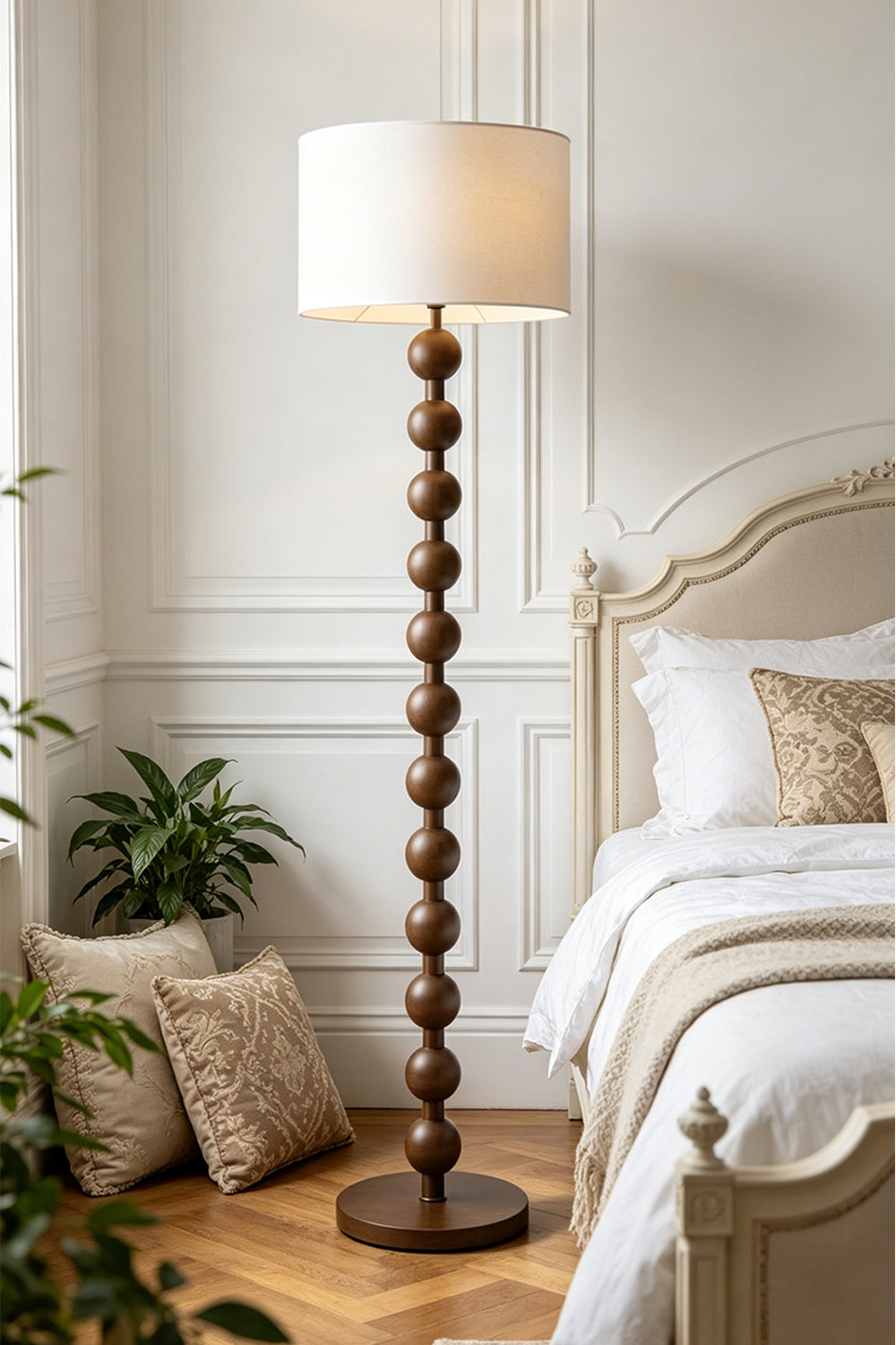 Marlow Stacked Wood Floor Lamp | Wood, Fabric | Illuminating a serene bedroom corner, casting a warm glow next to a white bed and paneled walls with wooden flooring | Samu Lamp