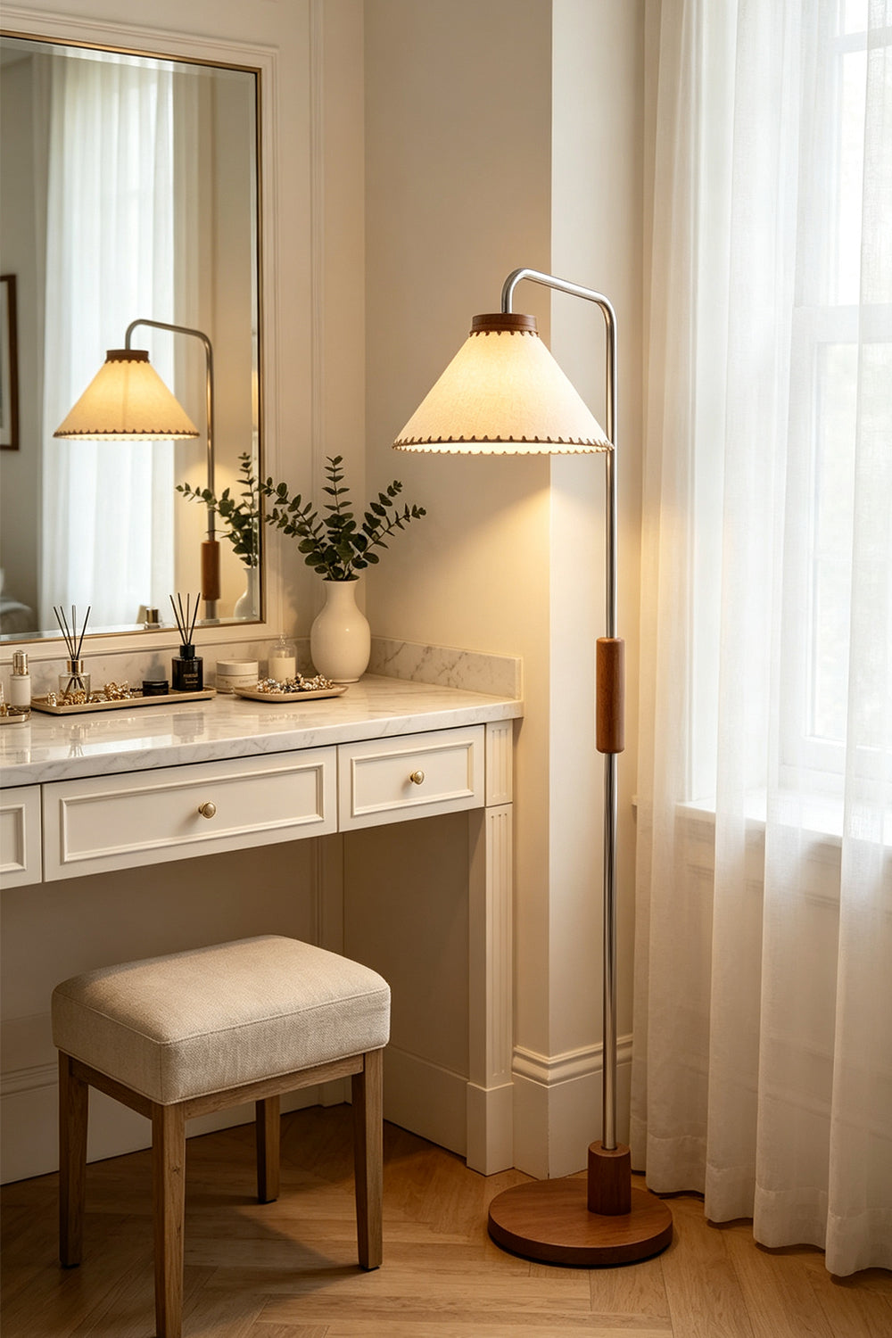 Marlowe Angled Linen Reading Floor Lamp | Linen, Wood, and Chrome Metal | Illuminating a bright makeup vanity area next to a white table with a mirror and a matching stool | Samu Lamp