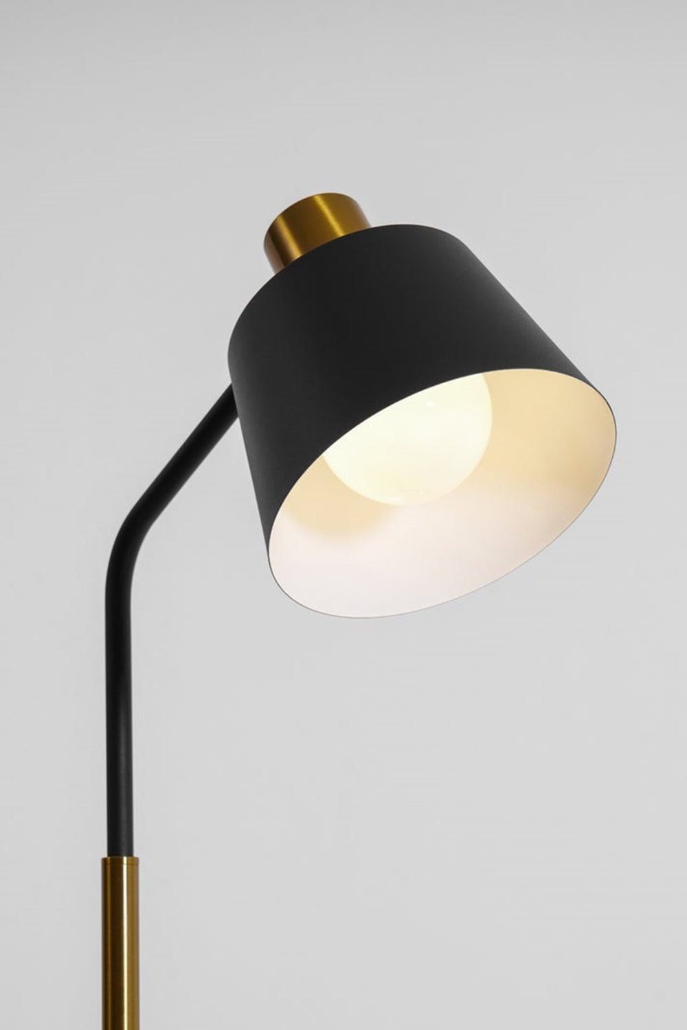 Marlowe Gooseneck Reading Floor Lamp | Matte Black and Brass | Focused shot of the illuminated lamp head providing directed task lighting | Samu Lamp