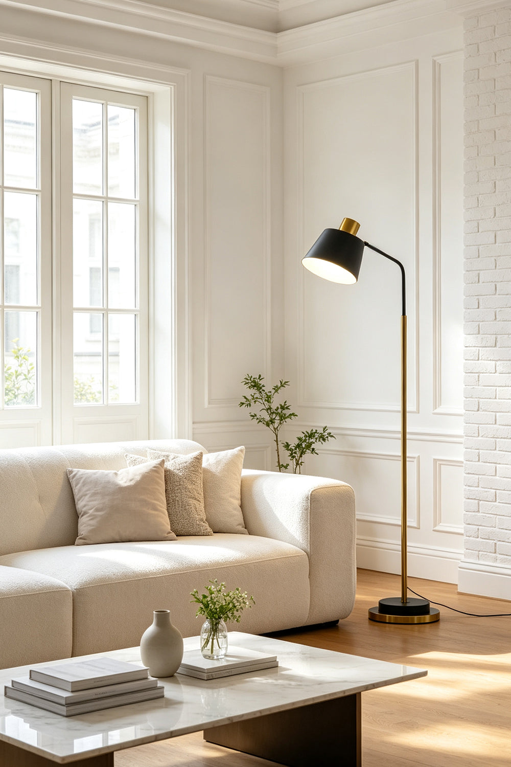Marlowe Gooseneck Reading Floor Lamp | Matte Black and Brass | Casting a warm reading light beside a cozy white sofa in a contemporary living room | Samu Lamp