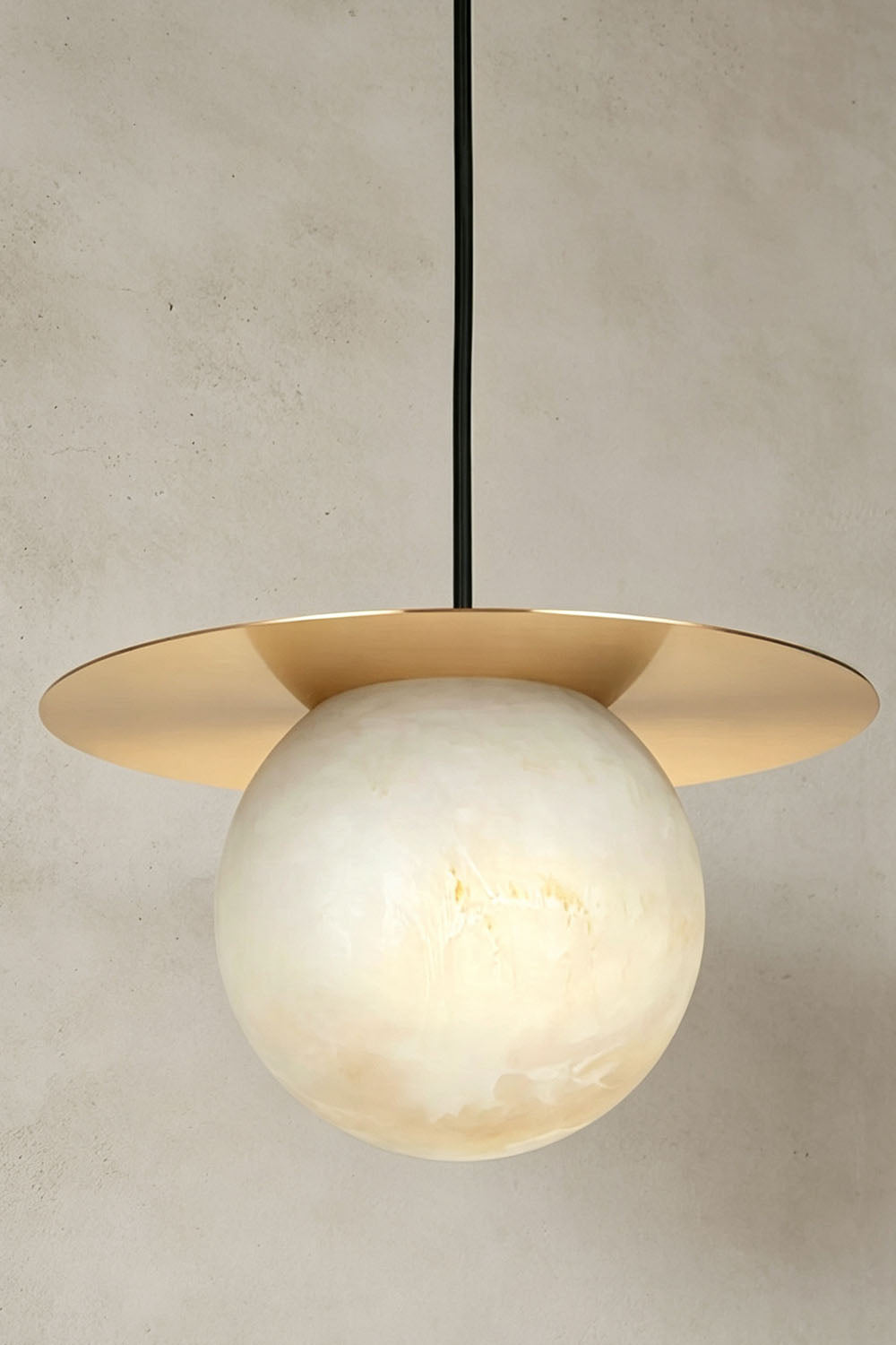 Marne Alabaster Sphere Brass Pendant Light | Natural Alabaster and Brass | Front close-up view displayed against a textured neutral wall | Samu Lamp