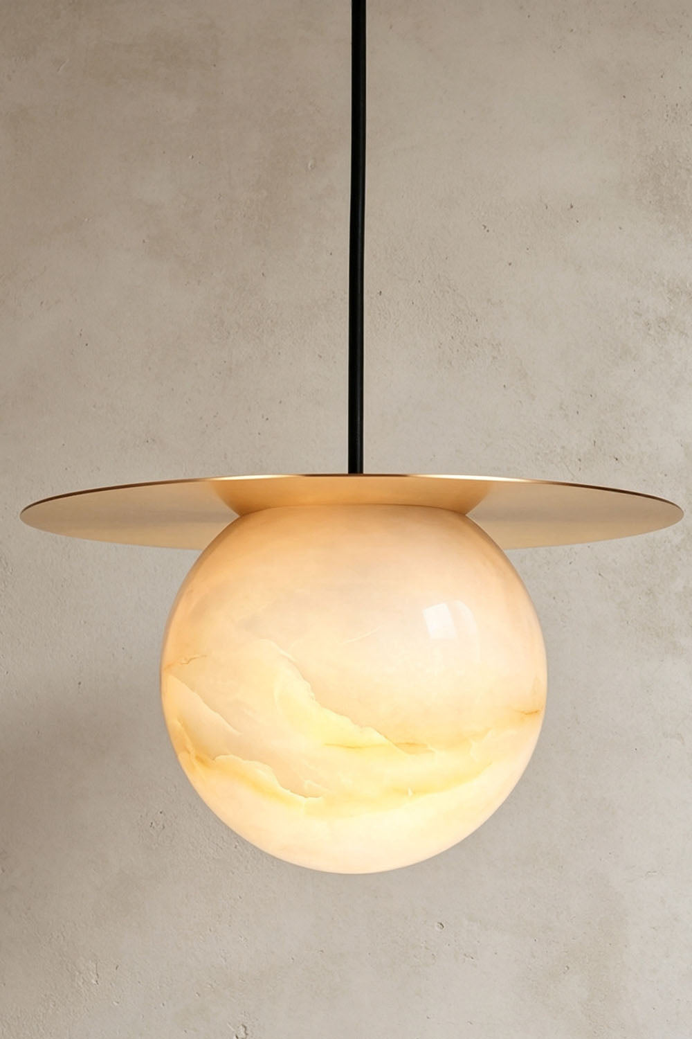 Marne Alabaster Sphere Brass Pendant Light | Natural Alabaster and Brass | Illuminated product shot showing the brass disc shade and alabaster globe | Samu Lamp