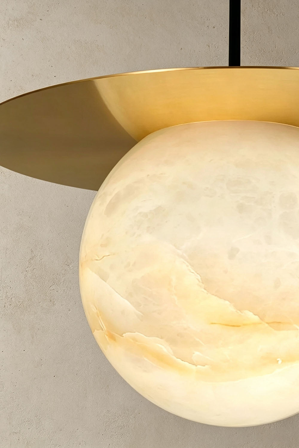 Marne Alabaster Sphere Brass Pendant Light | Natural Alabaster and Brass | Close-up shot showing the illuminated natural stone veining on the globe | Samu Lamp