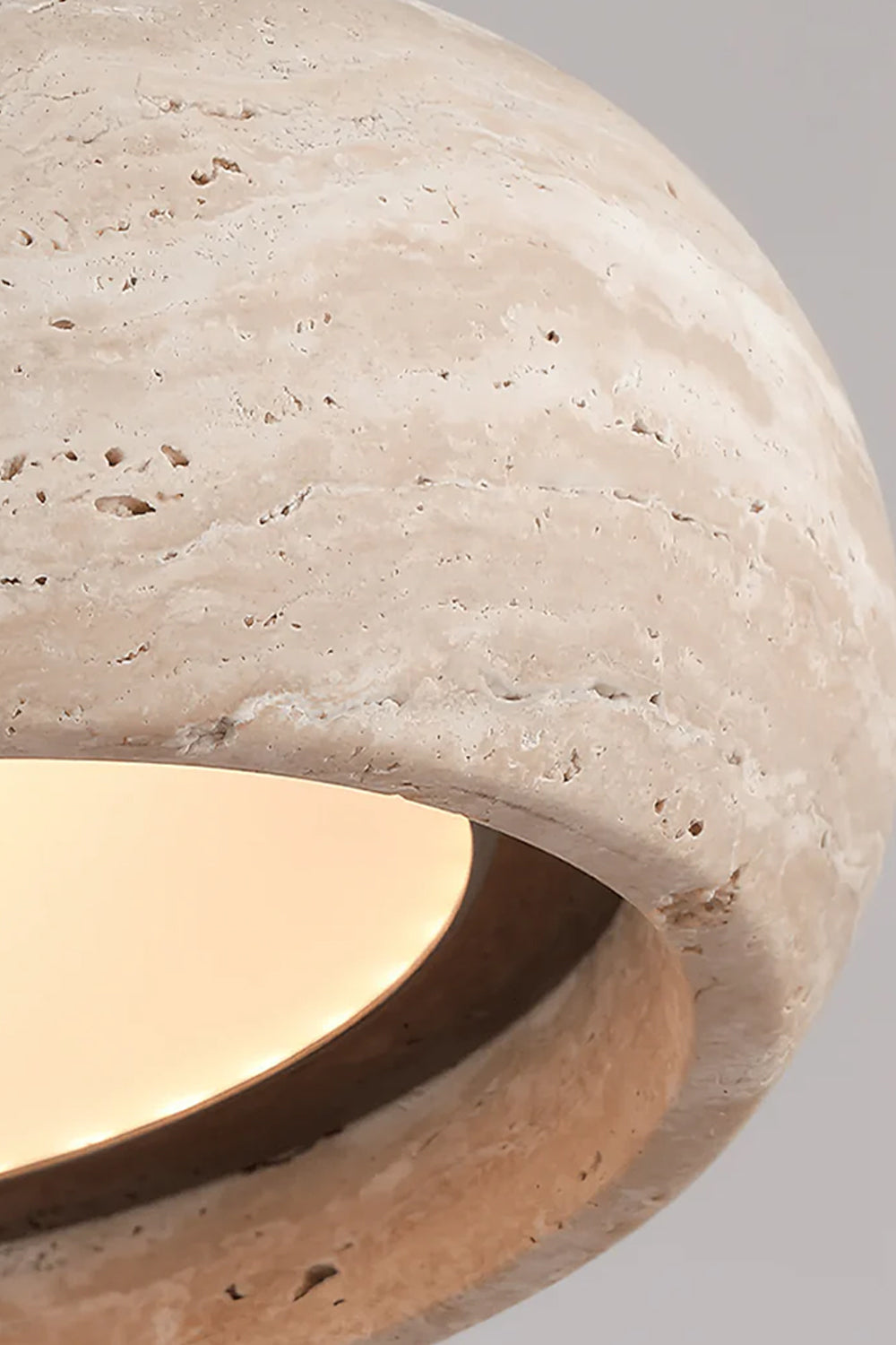 Maro Travertine Donut Pendant Light | Travertine, Metal | Close-up side profile view of the lit travertine donut shade highlighting its porous pitted texture and soft warm downlight | Detail shot | Samu Lamp