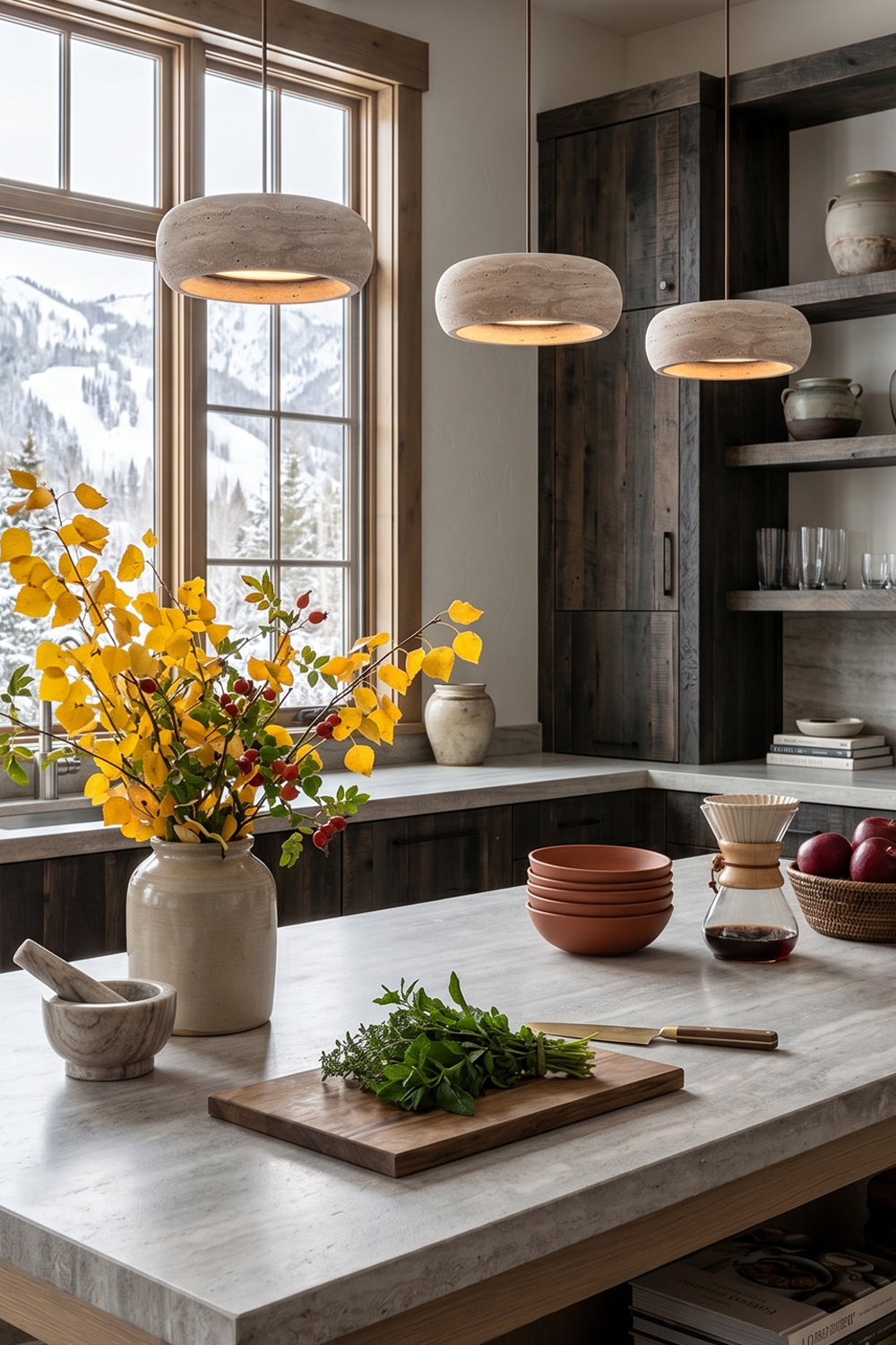 Maro Travertine Donut Pendant Light | Travertine, Metal | A trio of three linear travertine donut pendants illuminating a white marble kitchen island counter in a bright rustic kitchen | Samu Lamp