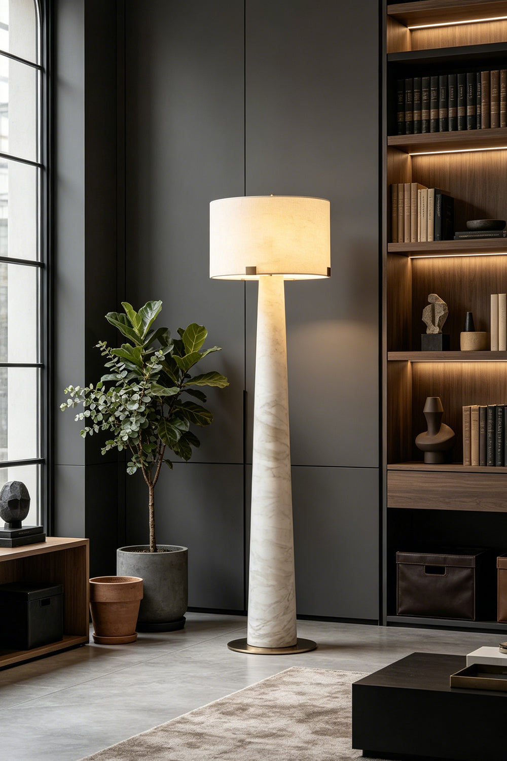 Meridian Column Alabaster Floor Lamp | Alabaster, Brass | Ambient lighting in a dark minimalist living area with bookshelves | Samu Lamp