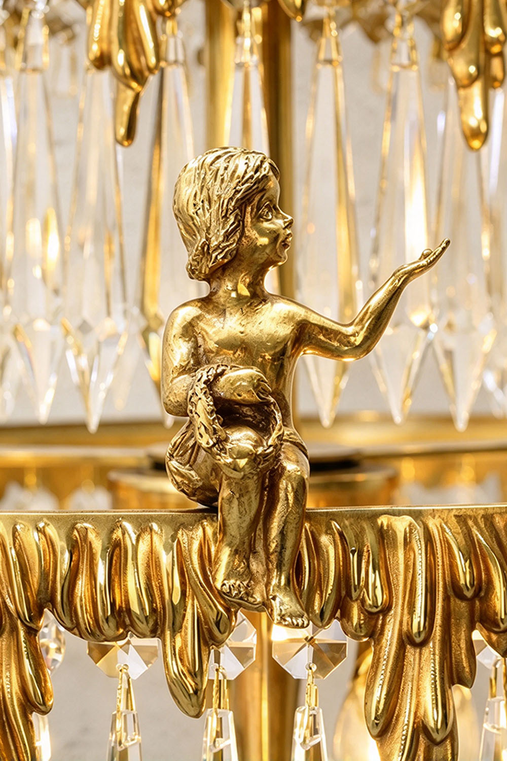 Mervaise Brass Cherub Crystal Tier Table Lamp | Brass and Crystal | Detail shot highlighting the carved brass cherub angel on crystal tier | Samu Lamp