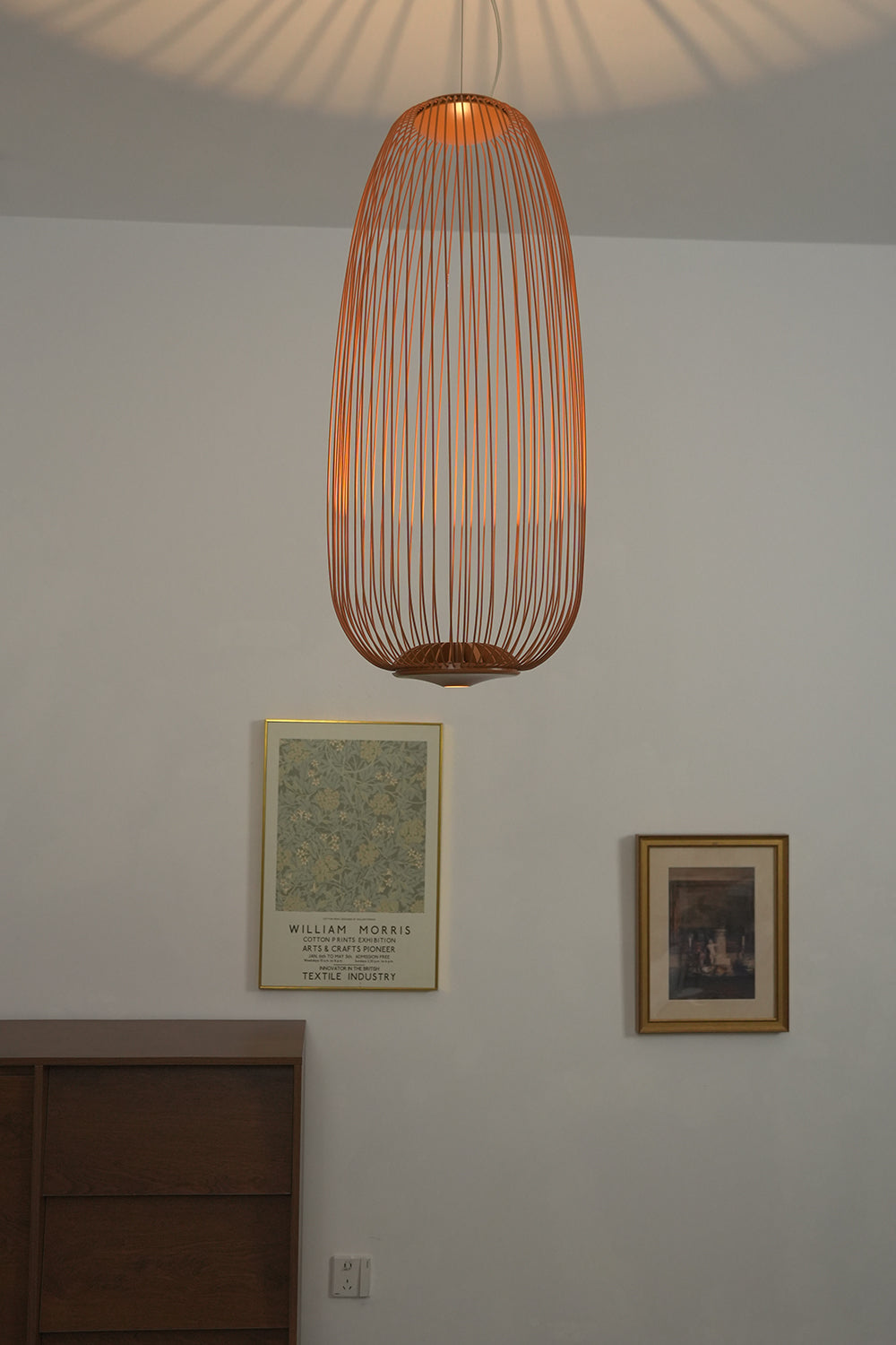 Copper elliptical wire cage pendant in hallway | Aluminum | Installed over a dark wood cabinet | Samu Lamp
