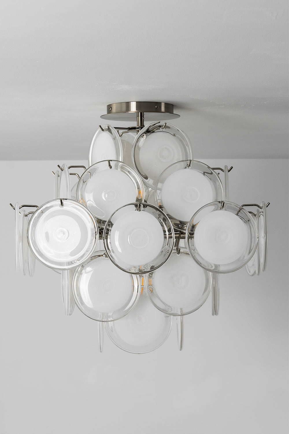 Mirella Circular Glass Pane Ceiling Light | Studio Unlit View | Studio perspective shot of the unlit semi-flush ceiling light displaying its elegant white glass disc silhouette against a grey wall | Samu Lamp
