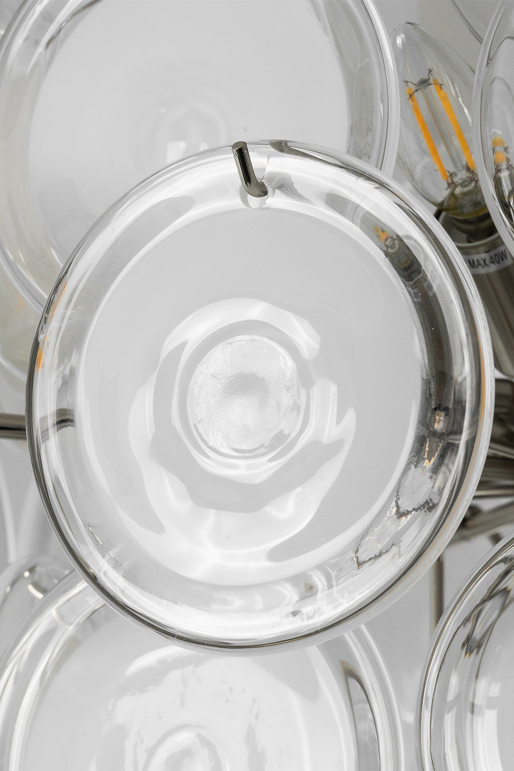 Mirella Circular Glass Pane Ceiling Light | Discs Texture Detail | Macro shot focusing on the layers of circular translucent glass panes secured onto the metallic structural framework | Detail shot | Samu Lamp