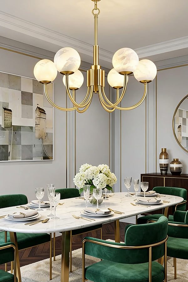 Minimalist brass globe chandelier | Alabaster, Brass | Installed in a bright dining room with green velvet chairs | Samu Lamp