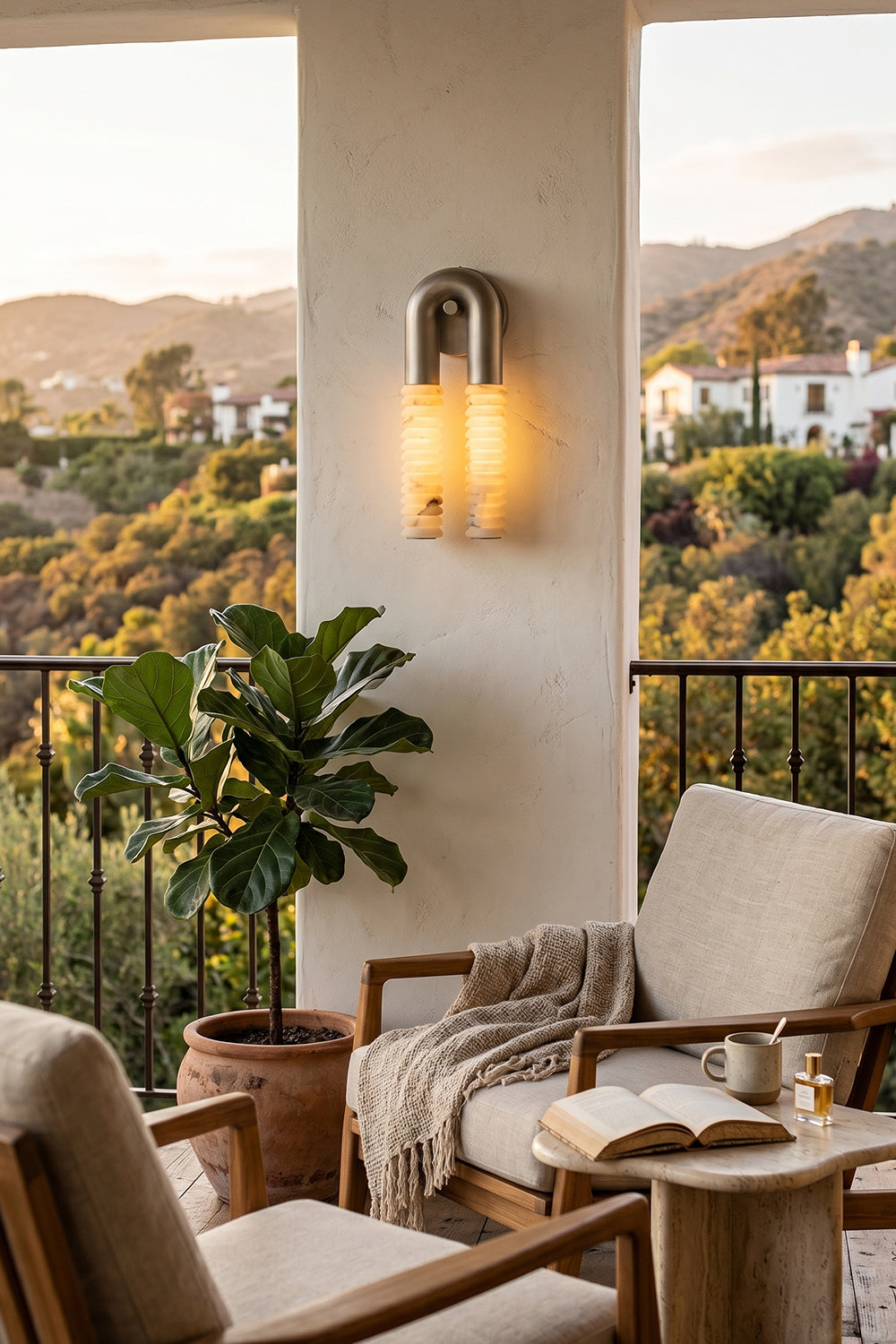 Monolith Arc Alabaster Wall Lamp | Alabaster, Metal | Outdoor terrace lighting at sunset with a comfortable lounge chair and scenic views | Samu Lamp