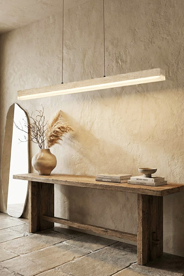 Natural travertine linear lamp against a stone wall | Travertine, Wood, Acrylic | Over a rustic wooden console table | Samu Lamp