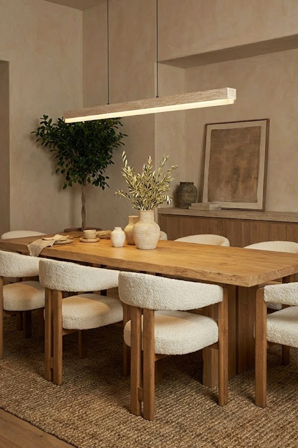 Linear stone pendant over a round-edge dining table | Travertine, Wood, Acrylic | Interior scene with white upholstered chairs | Samu Lamp