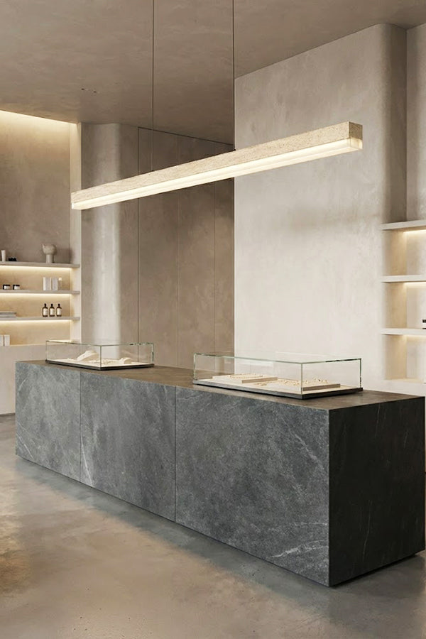 Long travertine linear light over a stone counter | Travertine, Wood, Acrylic | Commercial or gallery interior with minimalist decor | Samu Lamp