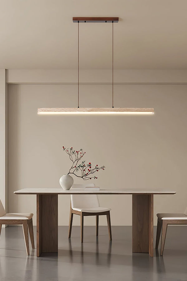 Modern organic linear pendant lamp | Travertine, Wood, Acrylic | Centered in a bright minimalist room over a simple table | Samu Lamp