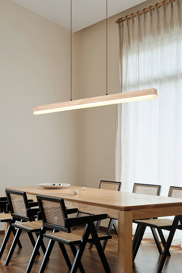 Travertine linear pendant lamp in a bright dining room | Travertine, Wood, Acrylic | Over a large wooden table with black chairs | Samu Lamp