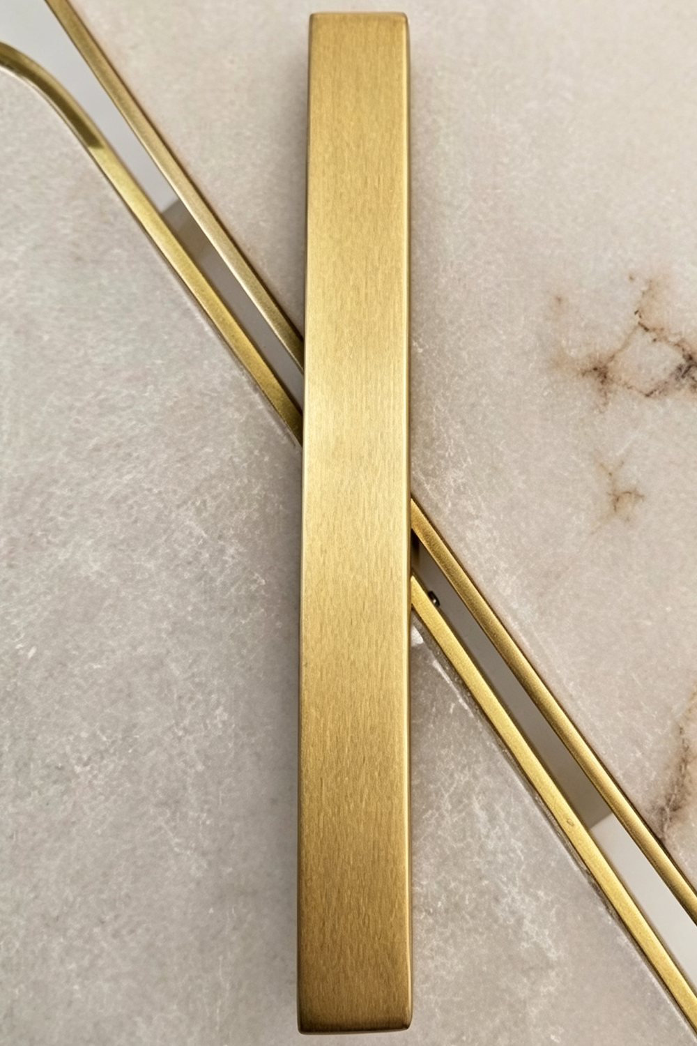 Nerine Overlapping Alabaster Wall Lamp with a sleek gold finish on a marble background.