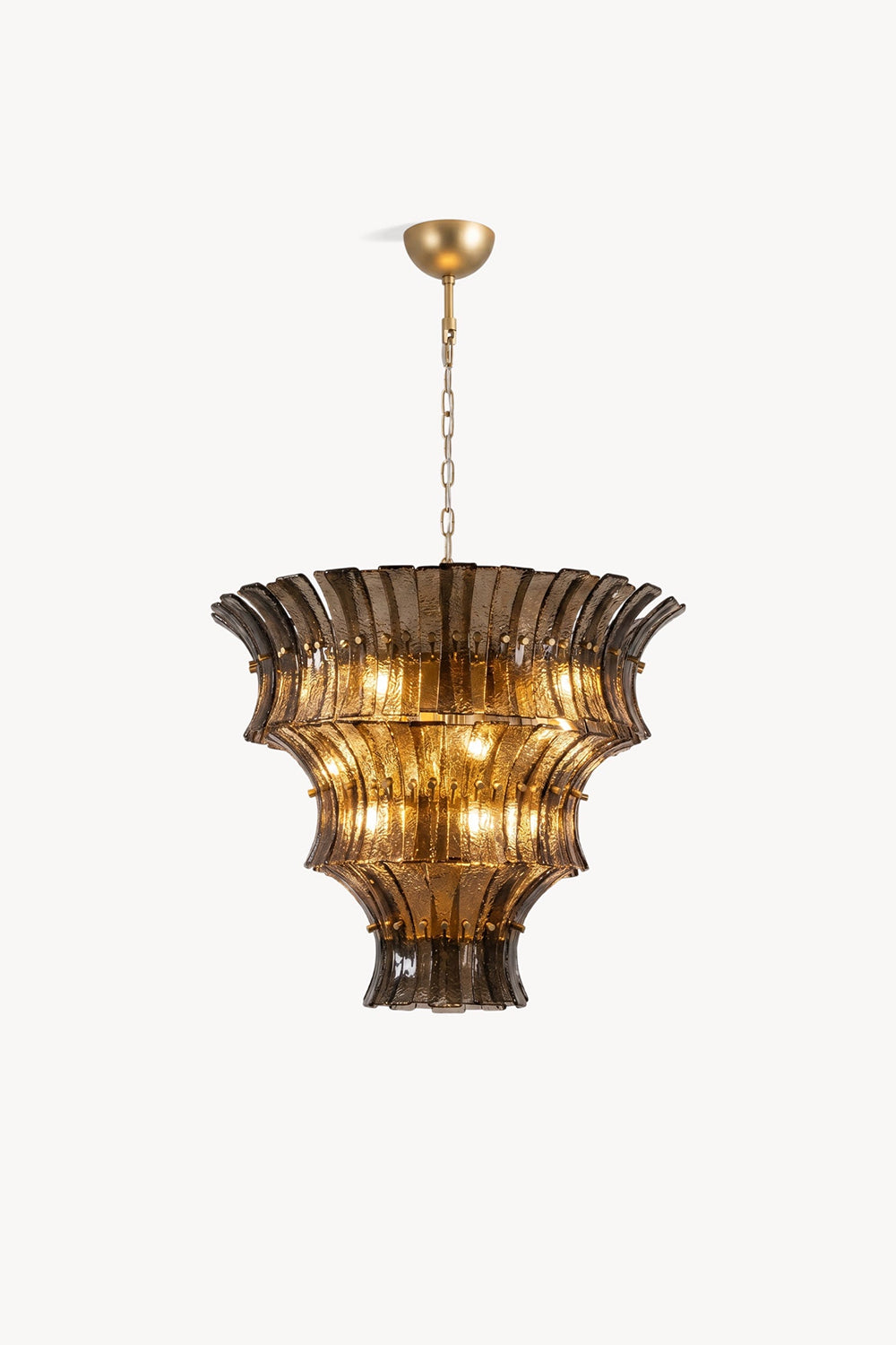 Octavia Sculptural Smoked Glass Chandelier | Studio Presentation | Clean front studio view of the tall tiered sculptural glass chandelier variant radiating a warm golden halo | Samu Lamp
