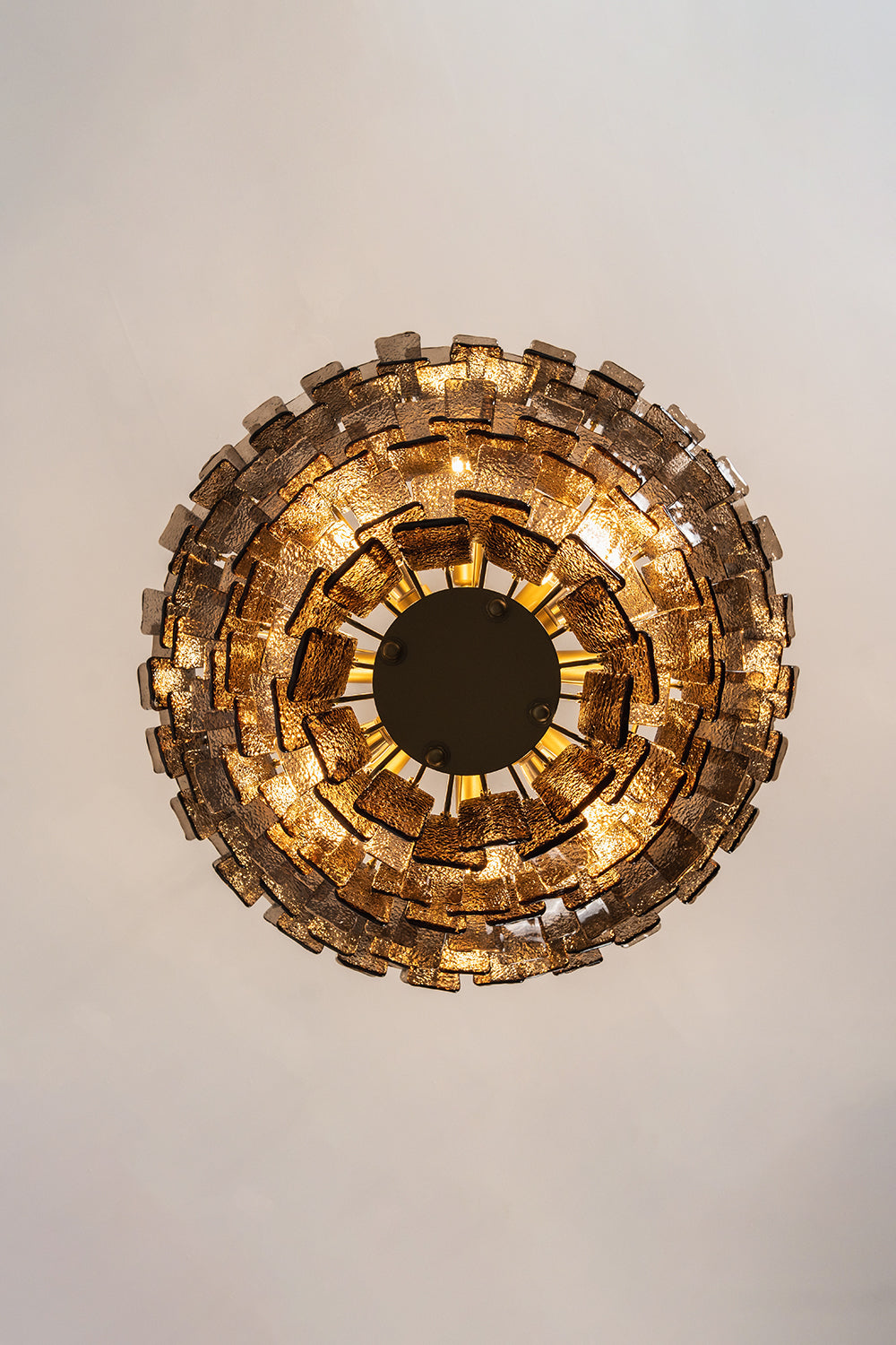 Octavia Sculptural Smoked Glass Chandelier | Bottom-Up View | Direct bottom-up look at the fully illuminated multi-tiered circular chandelier showcasing concentric rings of glowing glass | Samu Lamp