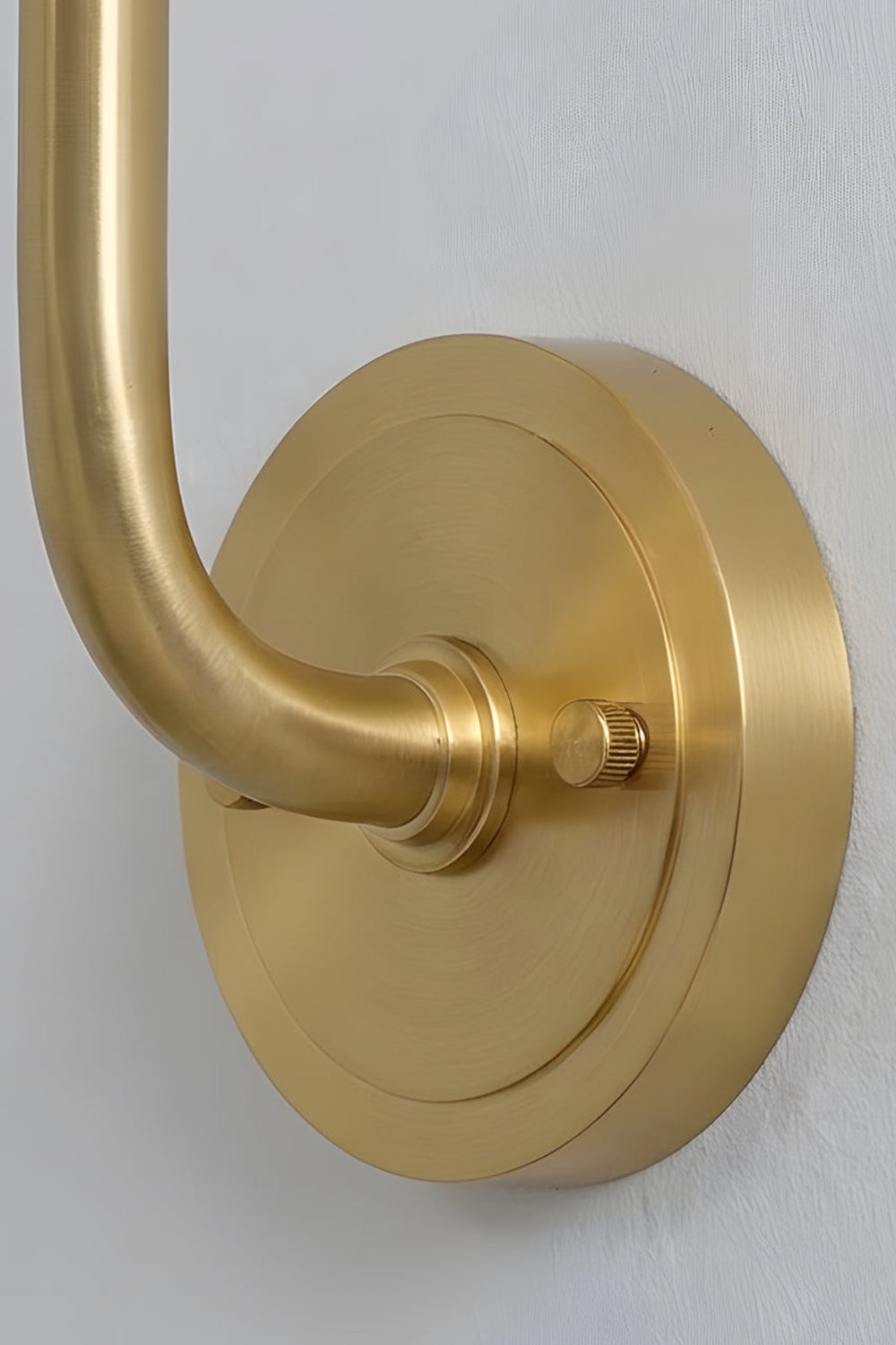 Odette Alabaster Curved Wall Sconce | Backplate Detail | Detailed close-up shot focusing on the premium round brushed gold brass mounting plate and the elegant curved gooseneck arm | Detail shot | Samu Lamp