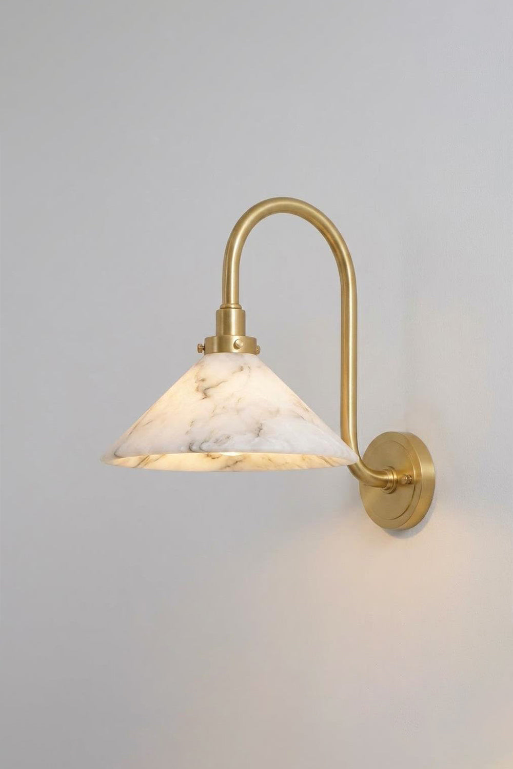 Odette Alabaster Curved Wall Sconce | Studio Lit View | Studio front angle presentation of the fully illuminated curved brass stone wall lamp casting a soft warm glow against a light backdrop | Samu Lamp