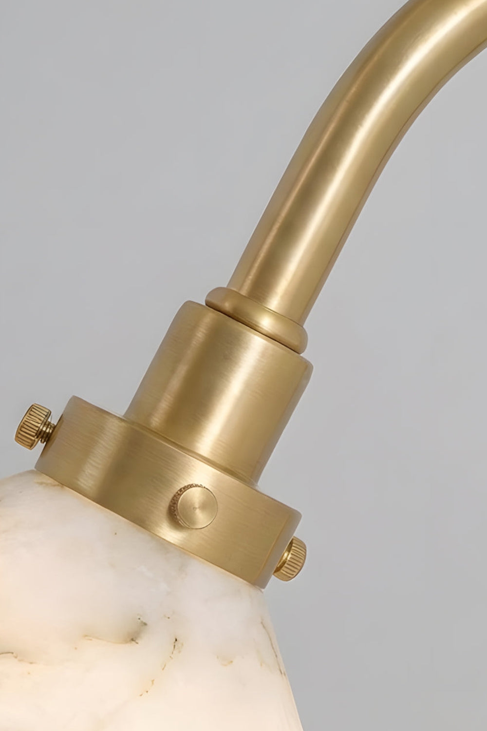 Odette Alabaster Curved Wall Sconce | Socket Collar Detail | Close-up focus on the high-quality gold brass socket cup and screw collar securing the top of the alabaster cone shade | Detail shot | Samu Lamp
