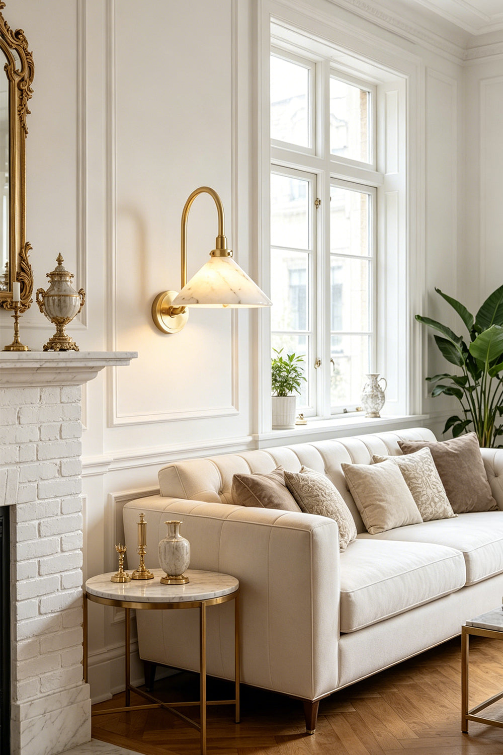 Odette Alabaster Curved Wall Sconce | Living Room Accent Lamp | Providing a warm ambient glow on a white classical wall above a comfortable cream fabric sofa next to a traditional fireplace | Samu Lamp