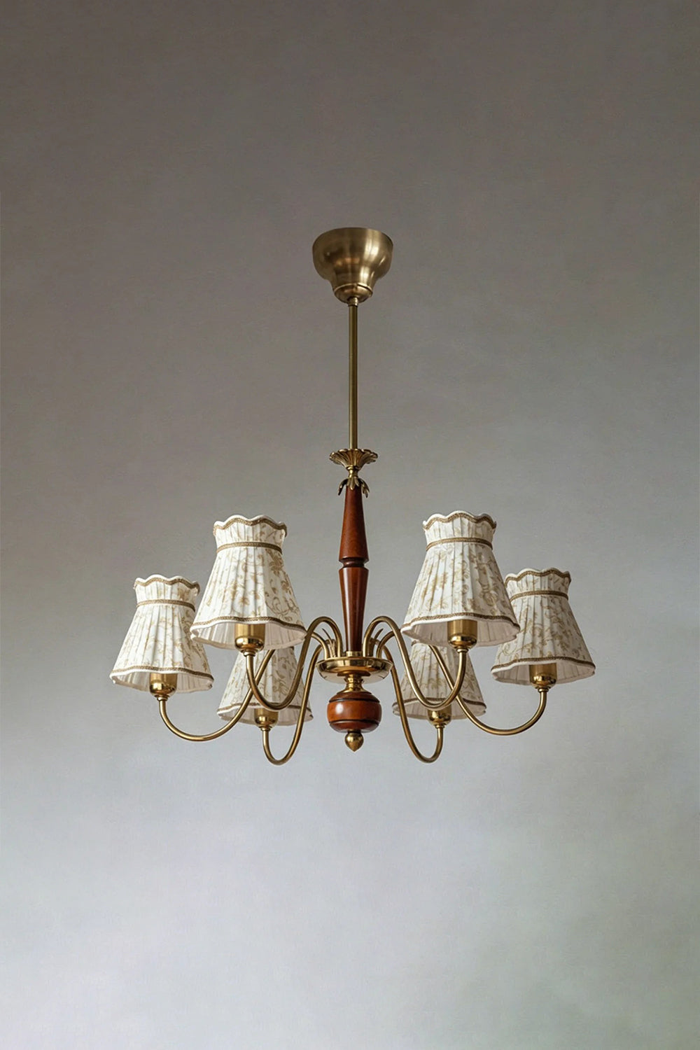 Odette Vintage Pleated Shaded Chandelier | Wood, Brass, Fabric | Studio front view of the unlit 6-light traditional shaded chandelier suspended against a plain neutral backdrop | Samu Lamp