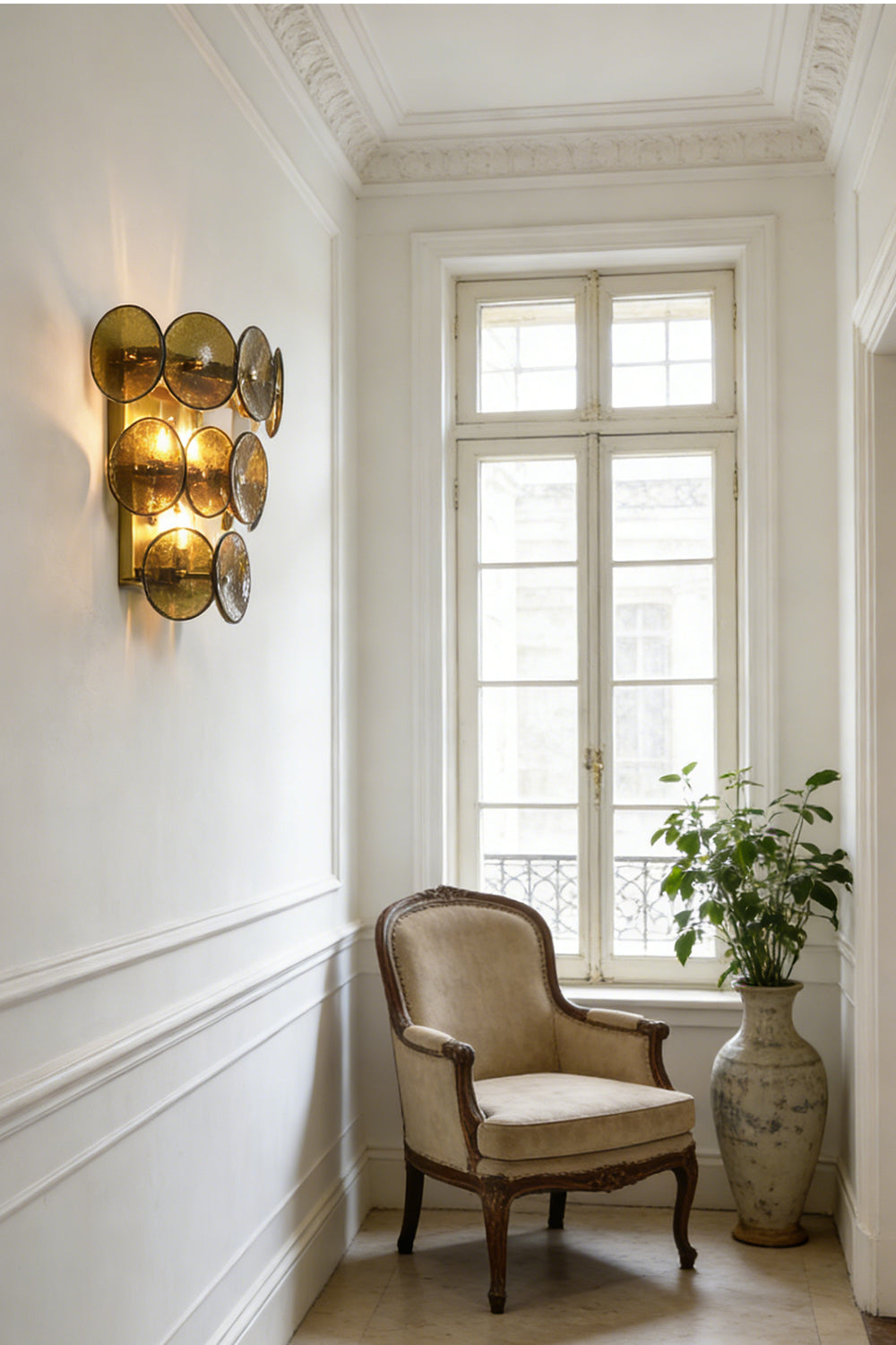 Lit tiered olive green glass disc lamp | Metal, Glass | Installed in a corner near a wicker basket | Samu Lamp