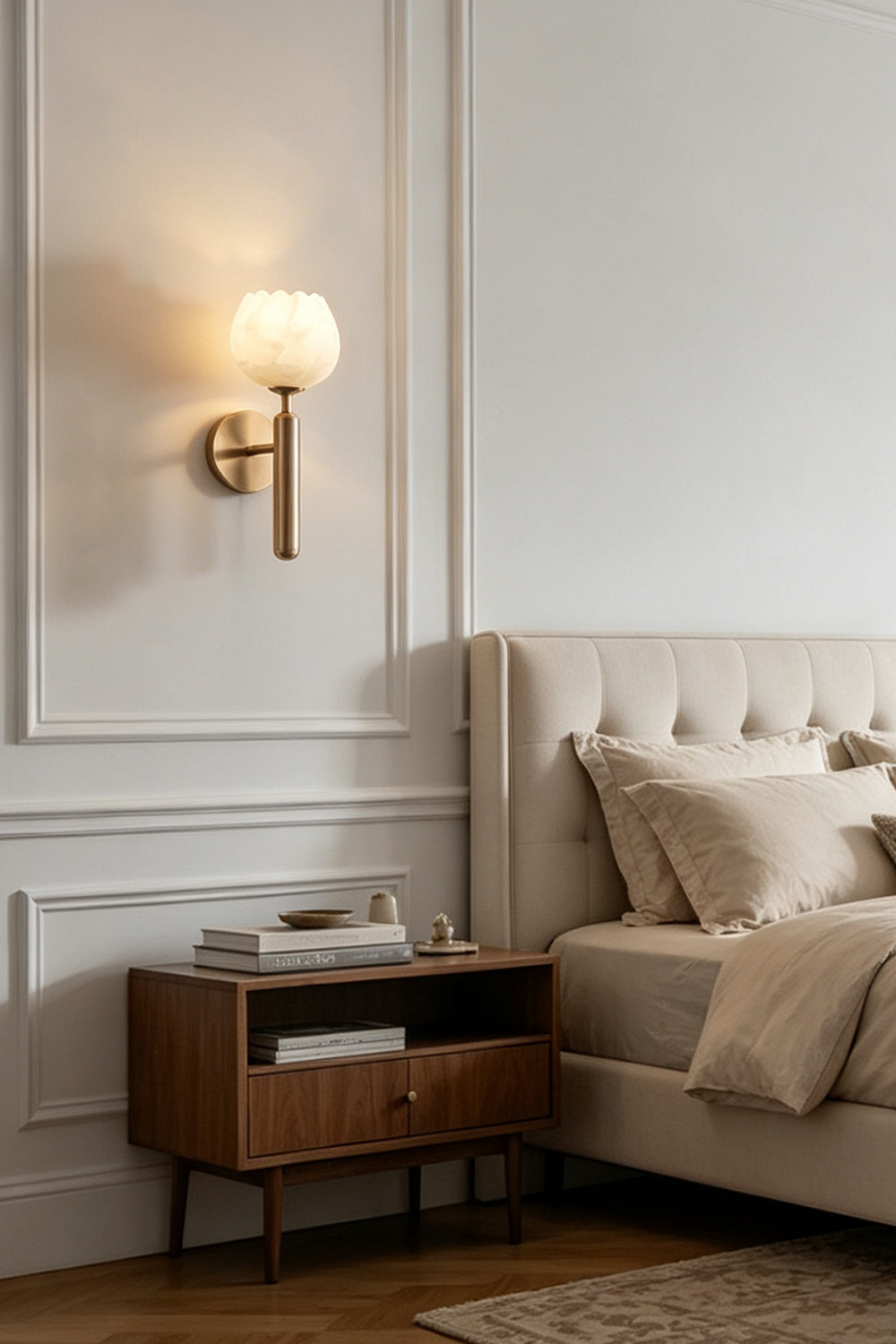 Ondine Alabaster Blossom Wall Sconce | Natural Alabaster and Brass | Installed as a bedtime reading light beside a tufted headboard and wooden nightstand in a bedroom | Samu Lamp