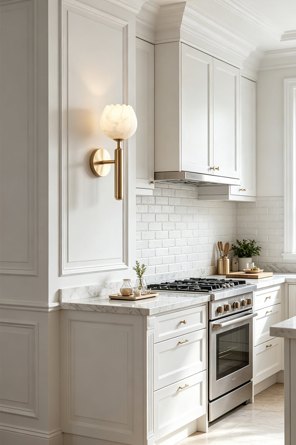 Ondine Alabaster Blossom Wall Sconce | Natural Alabaster and Brass | Fixed onto a white kitchen wall paneled backdrop casting ambient light near wooden island counters | Samu Lamp