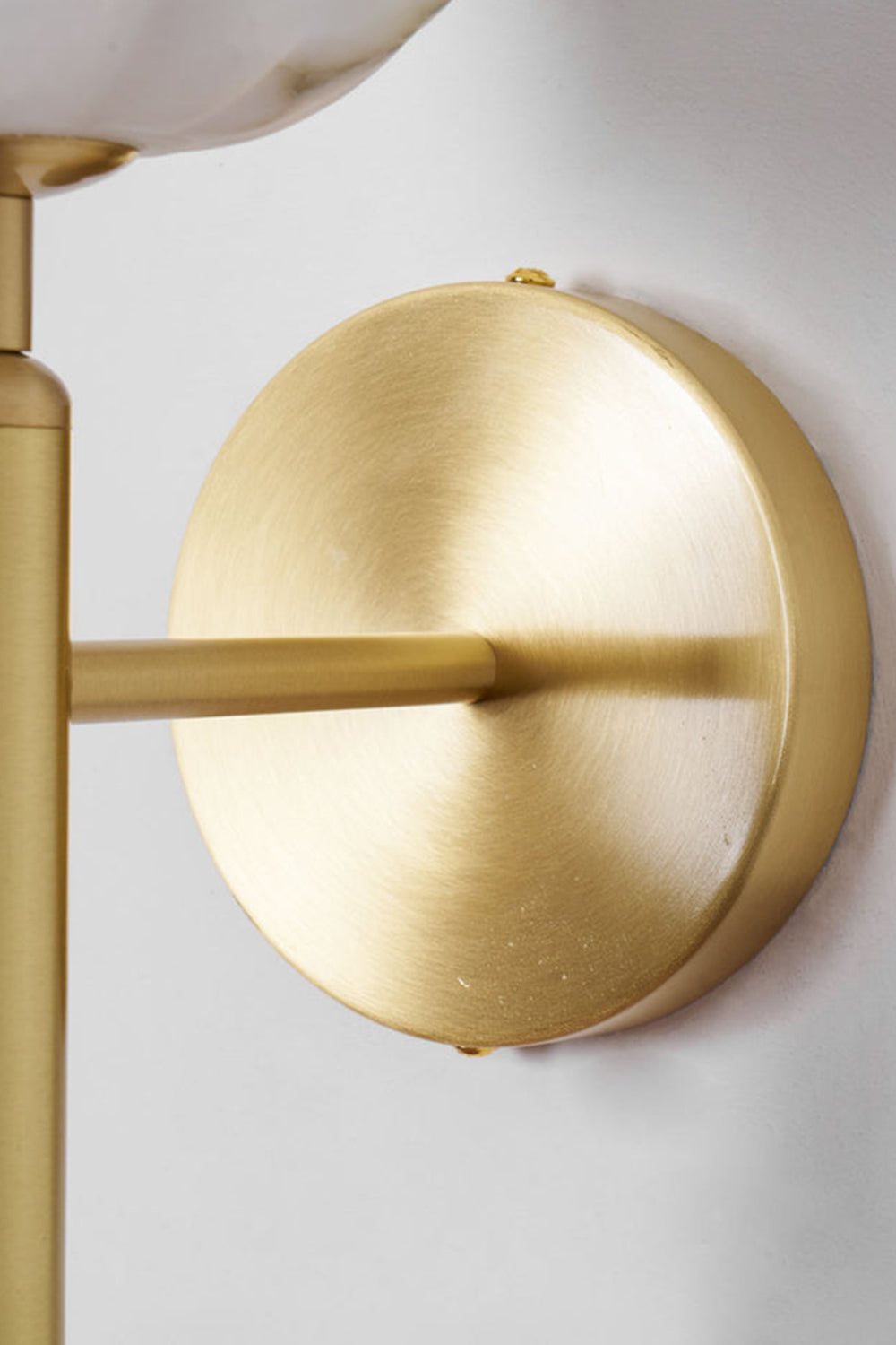 Ondine Alabaster Blossom Wall Sconce | Natural Alabaster and Brass | Close-up side view of the polished brass mounting hardware and circular base flush against a wall | Samu Lamp