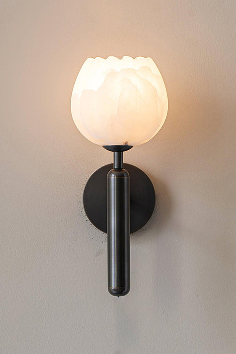 Ondine Alabaster Blossom Wall Sconce | Natural Alabaster and Black Metal | Full view of the illuminated tulip stone fixture featuring a matte black finish stem and base option | Samu Lamp