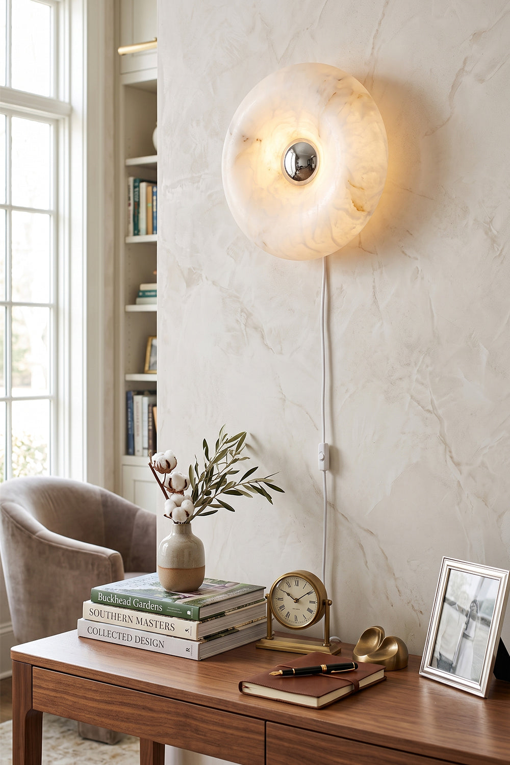 Ondine Ring Alabaster Wall Sconce illuminating a stylish interior with warm light.