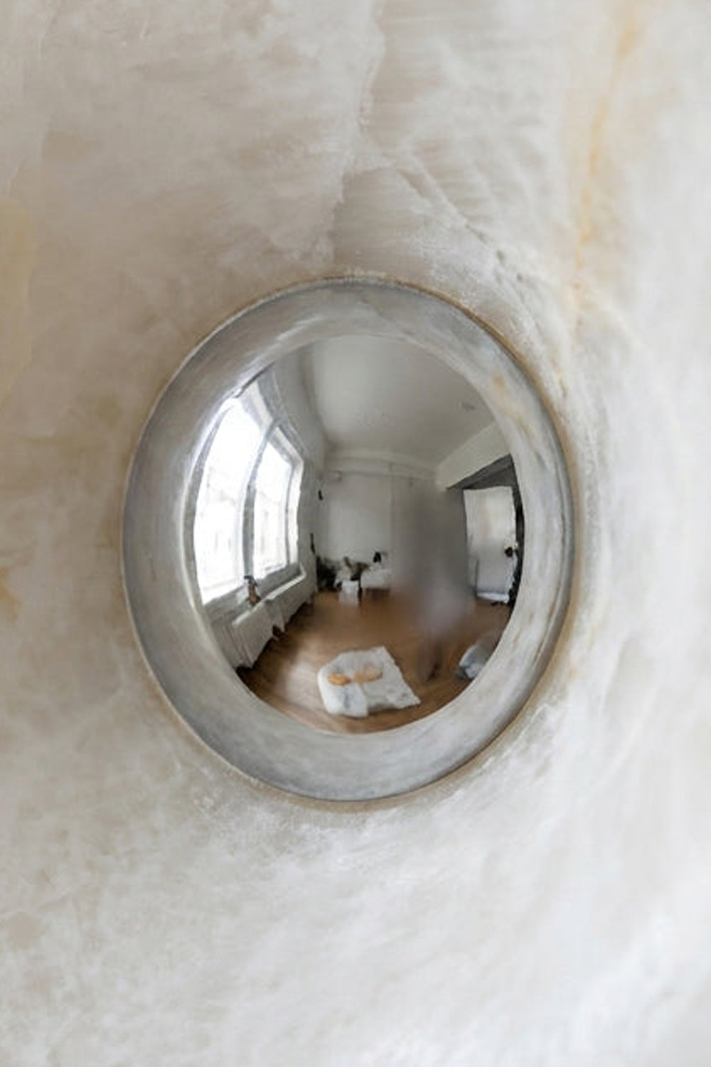 Reflective interior view through the Ondine Ring Alabaster Wall Sconce, showcasing its elegant design.