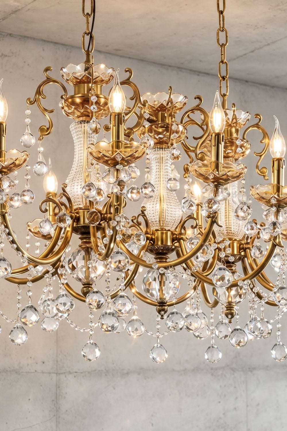 Orbessan Brass Crystal Oval Candle Chandelier | Cut Crystal and Brass | Close-up detail of ornate brass scrollwork with hanging crystal droplets | Samu Lamp