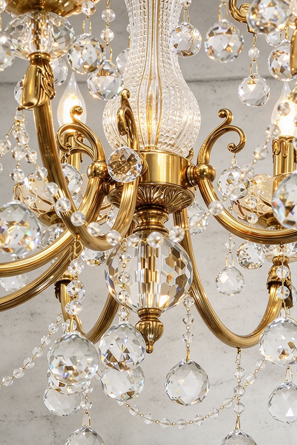 Orbessan Brass Crystal Oval Candle Chandelier | Cut Crystal and Brass | Close-up view of carved brass scroll arms and dangling crystal drops | Samu Lamp