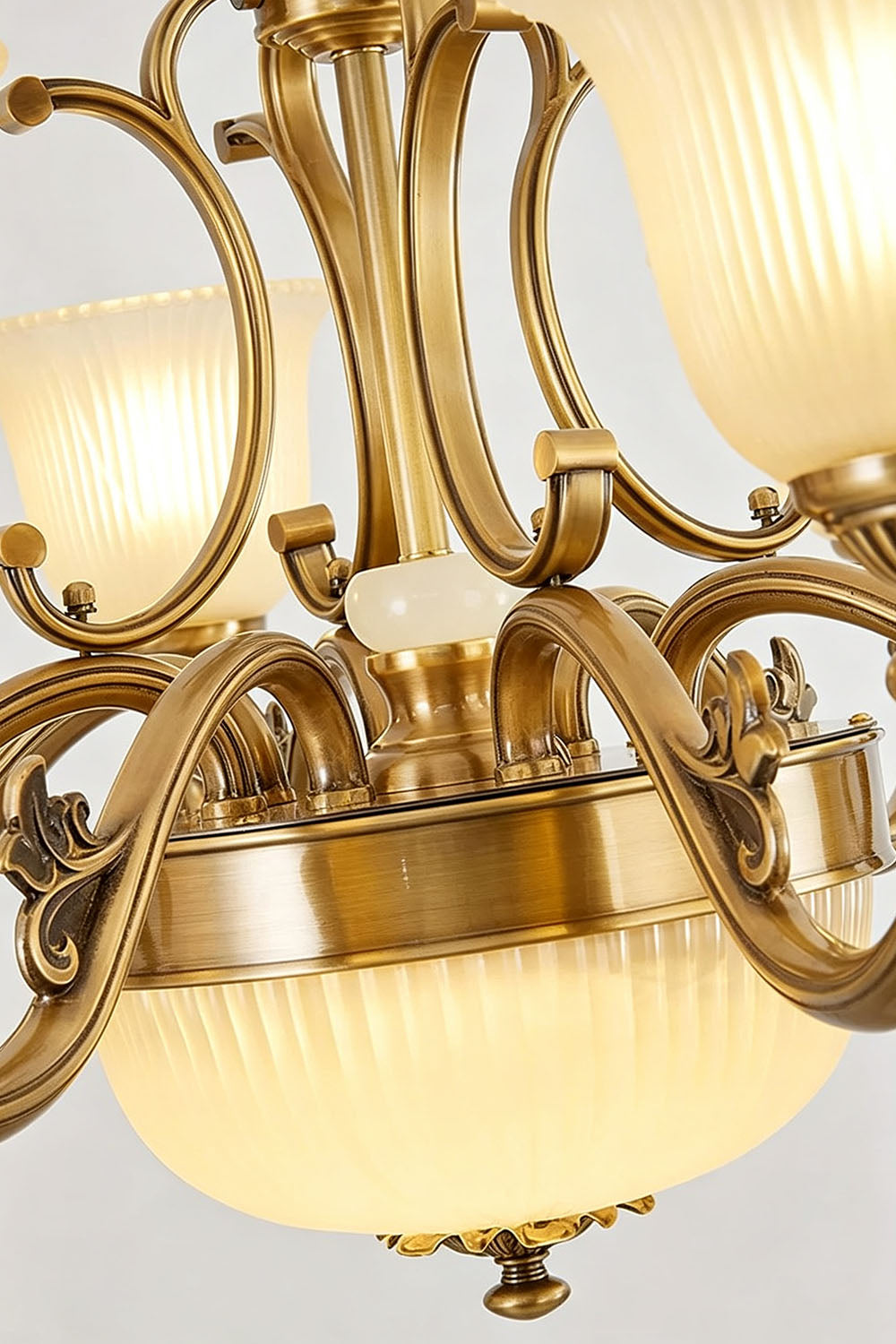 Close-up view of the Ormond Fluted Bell Brass Chandelier, showcasing its elegant brass finish and glass shades.